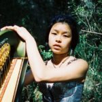Freedom Fly and her harp photographed in front of some trees